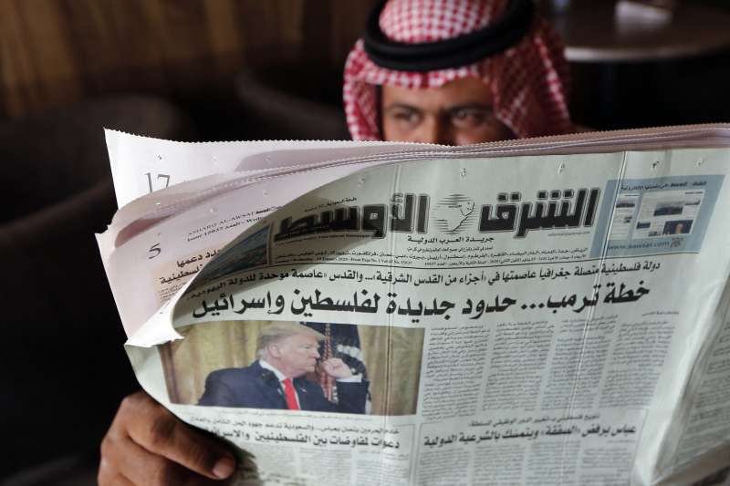 沙烏地阿拉伯的咖啡館內，一名男子看的報紙標題寫著阿拉伯聯合大公國（UAE）宣布與以色列建交。（AP）