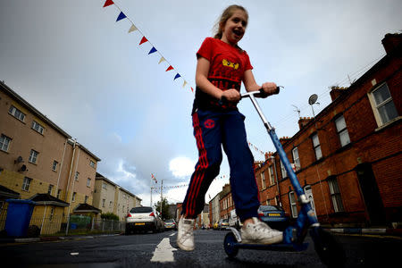 A girl rides a scooter in the walled-off loyalist Protestant enclave called The Fountain situated within the city of Londonderry, Northern Ireland, September 11, 2017. REUTERS/Clodagh Kilcoyne