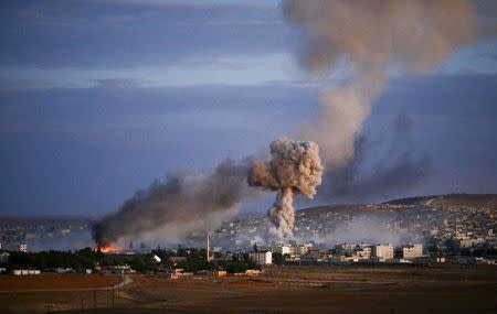 Smoke and flames rise over Syrian town of Kobani after an airstrike, as seen from the Mursitpinar crossing on the Turkish-Syrian border in the southeastern town of Suruc in Sanliurfa province, October 20, 2014. REUTERS/Kai Pfaffenbach