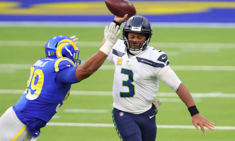 Aaron Donald prepares to hit Russell Wilson as he throws the ball.