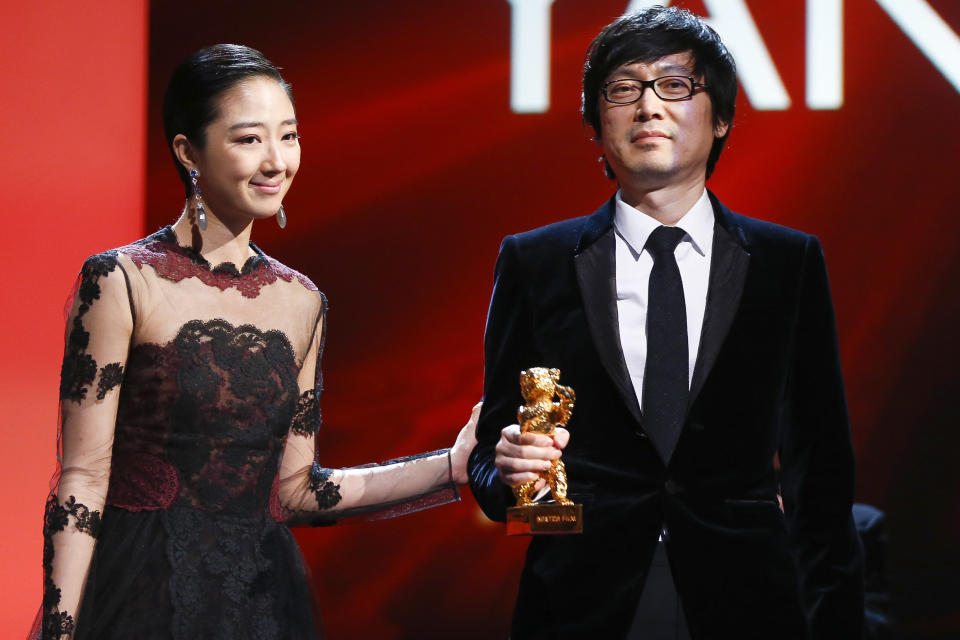 Director Diao Yina, right, holds the Golden Bear for Best Film for the movie Black Coal, Thin Ice, as he stands with actress Gwei Lun Meiduring during the award ceremony at the International Film Festival Berlinale in Berlin, Saturday, Feb. 15, 2014. (AP Photo/Axel Schmidt)