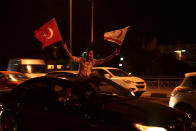 A supporter of a newly elected Turkish Cypriot leader Ersin Tatar holds Turkish and Turkish Cypriot flags and celebrates after winning the Turkish Cypriots election, in the Turkish occupied area in the north part of the divided capital Nicosia, Cyprus, Sunday, Oct. 18, 2020. Ersin Tatar, a hardliner who favors even closer ties with Turkey and a tougher stance with rival Greek Cypriots in peace talks has defeated the leftist incumbent in the Turkish Cypriot leadership runoff. (AP Photo/Nedim Enginsoy)