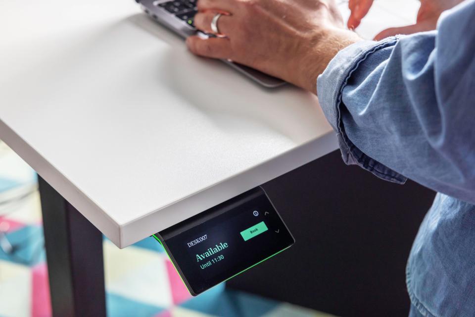 The Humly Booking Device under someone's desk in an office.