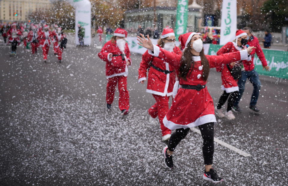 People wearing Santa Claus outfits take part in a charity race to collect funds to help victims of the Cumbre Vieja volcano eruption, in Madrid, Spain December 19, 2021. REUTERS/Juan Medina     TPX IMAGES OF THE DAY