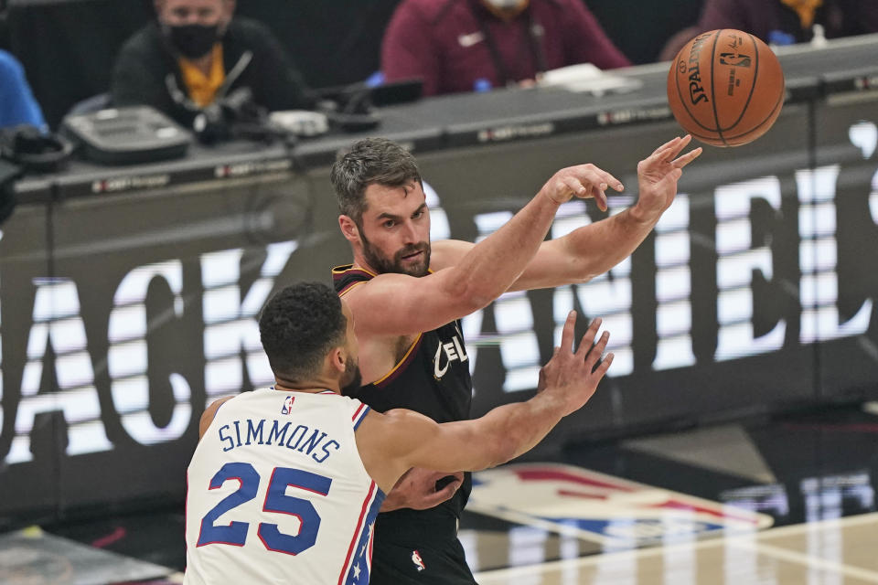 Cleveland Cavaliers' Kevin Love, right, passes against Philadelphia 76ers' Ben Simmons in the first half of an NBA basketball game, Sunday, Dec. 27, 2020, in Cleveland. (AP Photo/Tony Dejak)