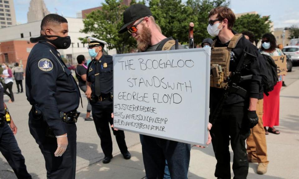 An armed man holds a sign during a rally against the death of George Floyd, in Detroit, Michigan.