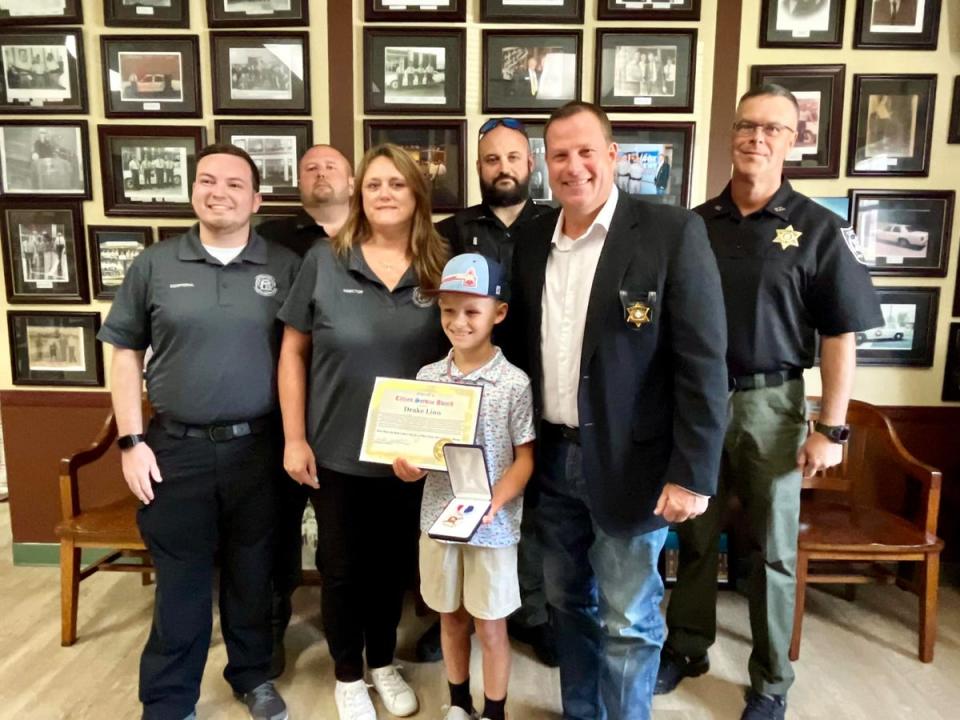 Drake Linn, 10, center, being honored by the Gordon County Sheriff’s Office in Georgia. The child saved his grandfather’s life after he went into a diabetic coma (Gordon County Sheriff’s Office)