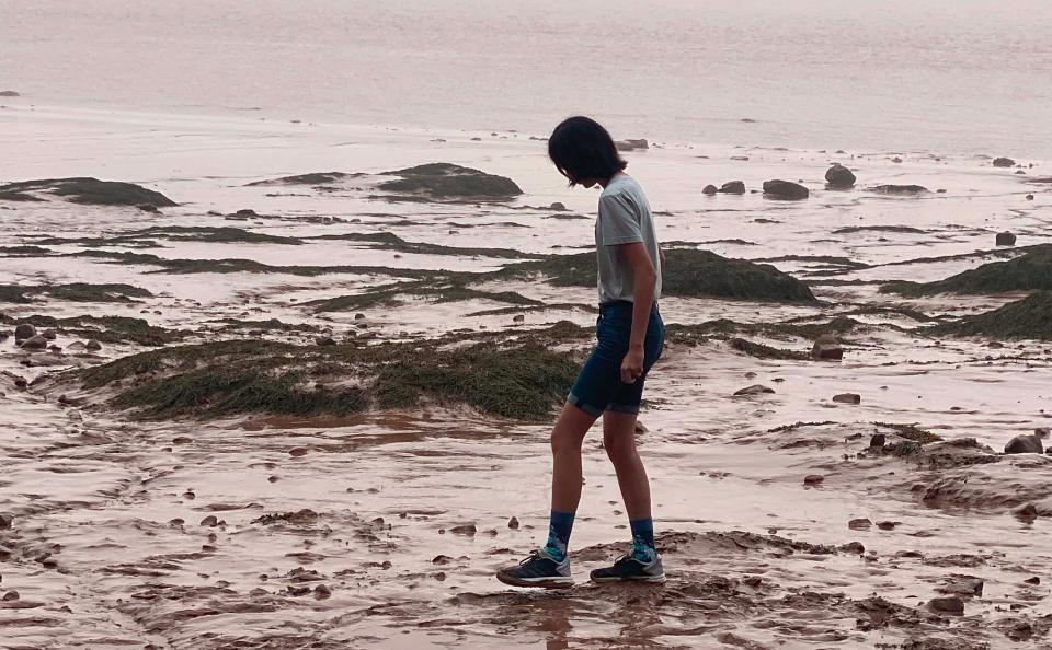 JoAnn Chang's child Remy walking on a beach.