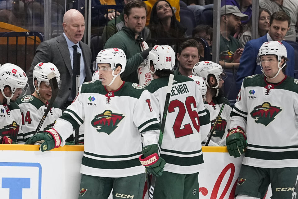 Minnesota Wild head coach John Hynes, top left, talks to his players during the first period of an NHL hockey game against the Nashville Predators, Thursday, Nov. 30, 2023, in Nashville, Tenn. (AP Photo/George Walker IV)