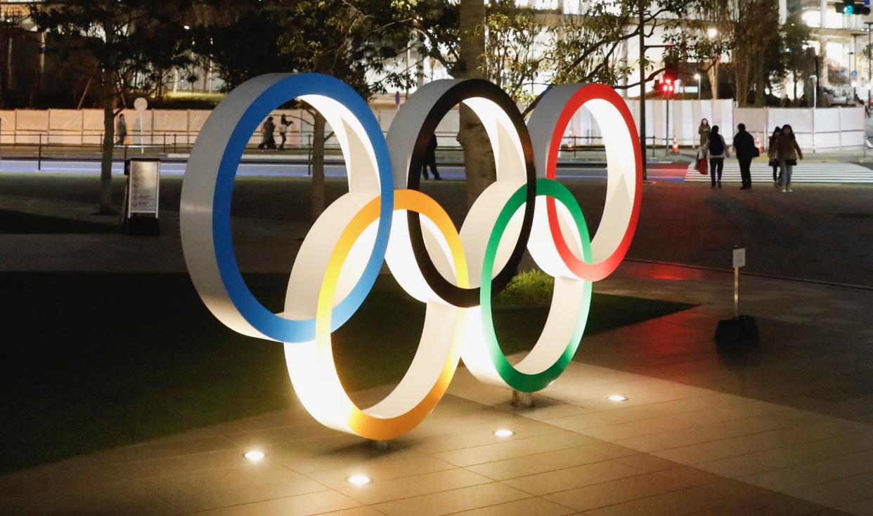 The Olympic rings stand near the new National Stadium Sunday, Dec. 15, 2019, in Tokyo.                                                                                                         