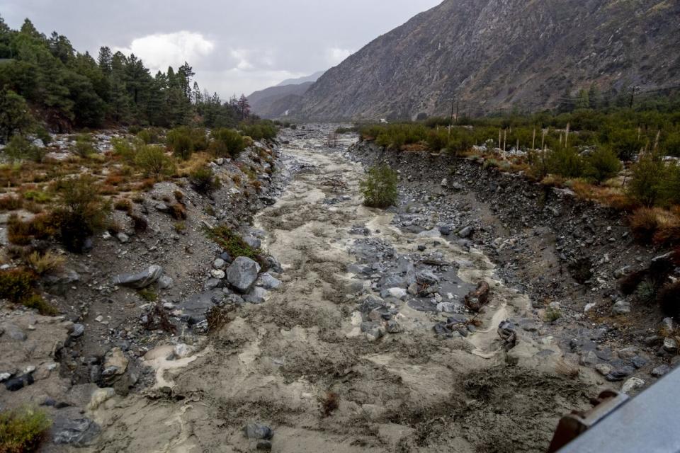 A creek bed filled with mud, rocks and debris in a mountainous area