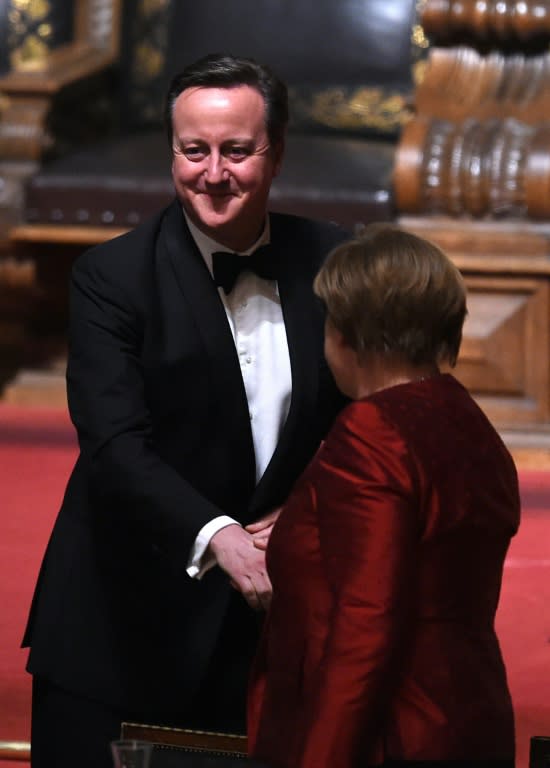 German Chancellor Angela Merkel (R) shakes hands with British Prime Minister David Cameron after his speech at the Matthiae-Mahr Dinner in Hamburg, on February 12, 2016