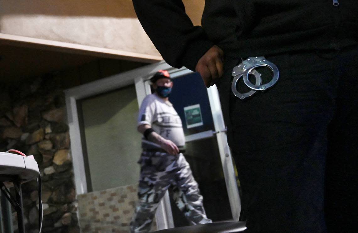 A Pacific Valley Patrol security guard wears handcuffs as she maintains a station outside of a former motel turned into housing for the homeless Tuesday, April 5, 2022 in Fresno.