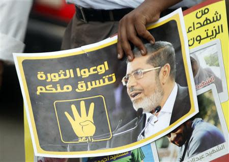 A member of the Muslim Brotherhood and supporter of ousted Egyptian President Mursi holds a poster during a protest named "People Protect the Revolution" as they march towards the "Qasr al-Quba" presidential palace in Cairo, September 6, 2013. Egypt's army-backed authorities have decided to annul the Muslim Brotherhood's non-governmental organisation, an official said on Friday, widening a drive to neutralise the movement behind Mursi. The poster reads, "Do not let the revolution steal from you" and it also shows the "Rabaa" or "four" gesture, in reference to the police clearing of Rabaa al-Adawiya protest camp on August 14. REUTERS/Amr Abdallah Dalsh