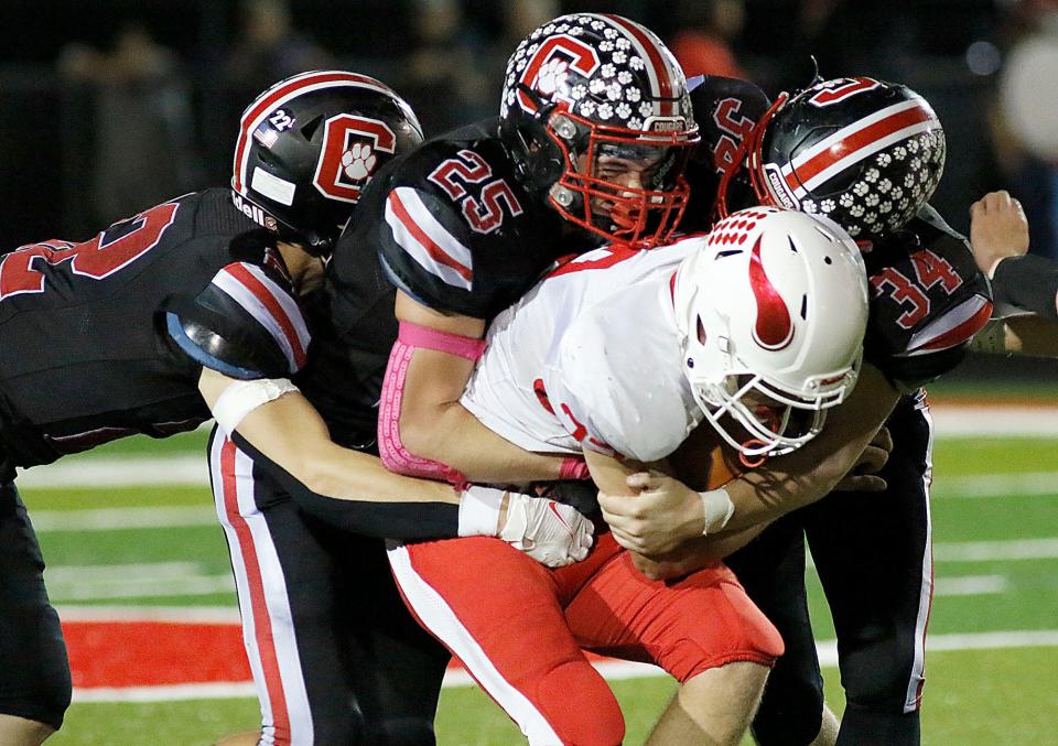 Plymouth High School's Trace McVay (32) is tackled by Crestview High School's Brier Godsey (22, Owen Barker (25) and Gavin Cains (34) during high school football action Friday, Oct. 8, 2021 at Crestview High School. TOM E. PUSKAR/TIMES-GAZETTE.COM