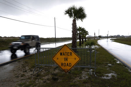 A car passes a sign after Tropical Storm Gordon in Dauphin Island, Alabama, U.S., September 5, 2018. REUTERS/Jonathan Bachman