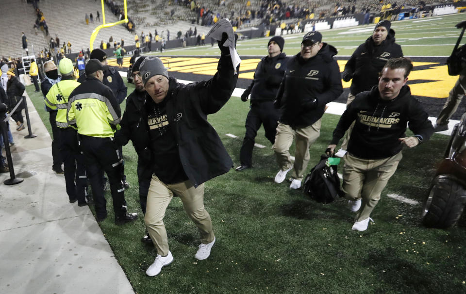 Purdue head coach Jeff Brohm (L) waves to fans as he runs off the field after an NCAA college football game against Iowa, Saturday, Nov. 18, 2017, in Iowa City, Iowa. Purdue won 24-15. (AP Photo/Charlie Neibergall)