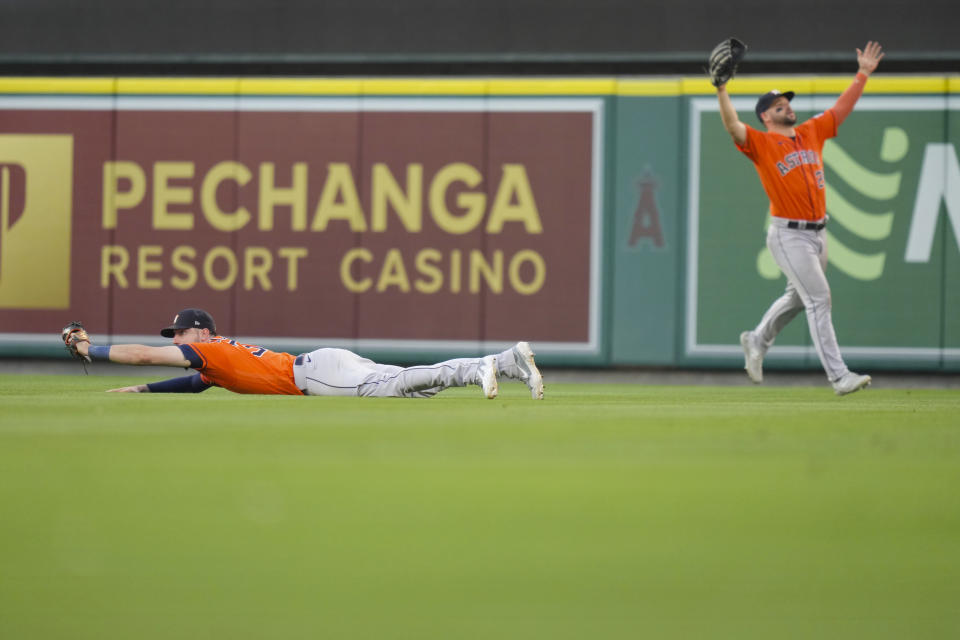 Houston Astros right fielder Kyle Tucker, left, holds on to a caught ball to record the final out as teammate center fielder Chas McCormick (20) reacts to the win during the ninth inning of a baseball game agains the Los Angeles Angels in Anaheim, Calif., Sunday, July 16, 2023. (AP Photo/Eric Thayer)
