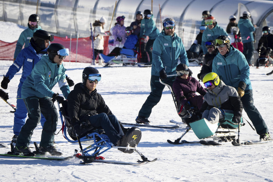 Prince Harry, The Duke of Sussex, center, sit skis with Invictus athletes during the Invictus Games training camp in Whistler, British Columbia, on Wednesday, Feb. 14, 2024. (Ethan Cairns/The Canadian Press via AP)