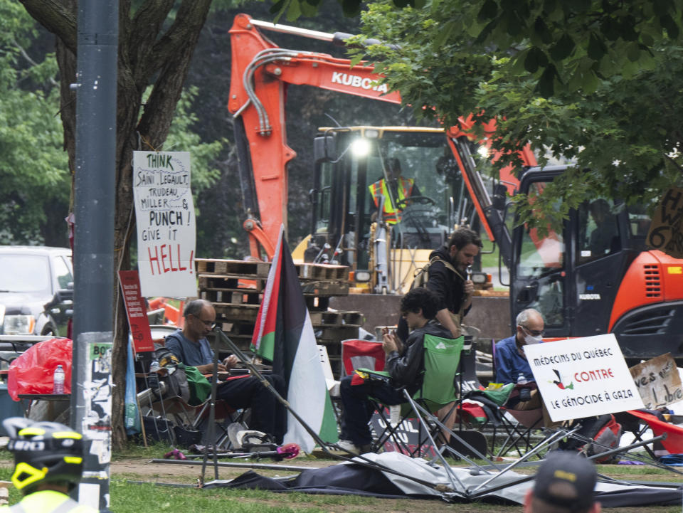 Protesters sit as private security workers dismantle the encampment on McGill University campus Wednesday, July 10, 2024, in Montreal. (Ryan Remiorz/The Canadian Press via AP)