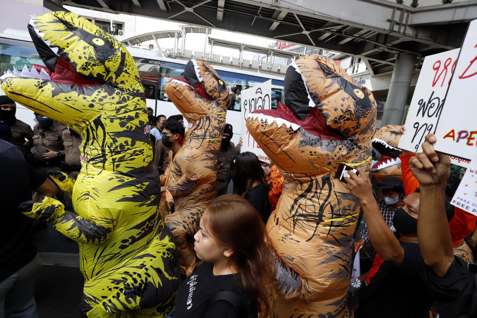 Protesters wear dinosaur costumes during a demonstration near the Asia-Pacific Economic Cooperation (APEC) forum venue, Thursday, Nov. 17, 2022, in Bangkok Thailand. A small but noisy group of protesters scuffled briefly with police demanding to deliver a letter to leaders attending the summit demanding various causes including removal of Prime Minister Prayuth Chan-ocha and abolition of Thailand's strict royal defamation laws. (AP Photo/Sarot Meksophawannakul)