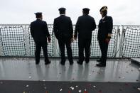 Colleagues of the cabin crew of Sriwijaya Air flight SJ 182, which crashed into the sea, stand on the deck of Indonesia's Naval ship KRI Semarang, as they visit the site of the crash to pay their tribute at the sea off the Jakarta coast