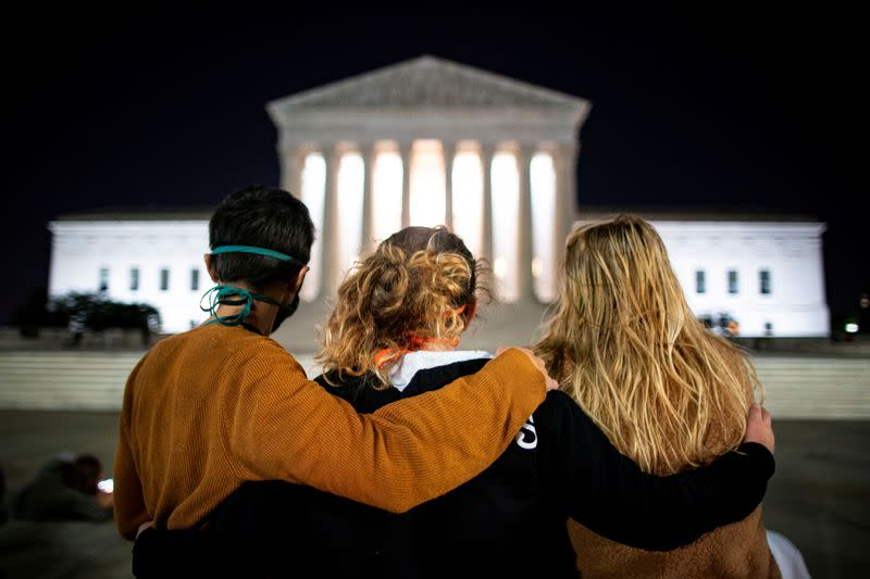 People stand in front of the U.S. Supreme Court following the death of U.S. Supreme Court Justice Ruth Bader Ginsburg, in Washington