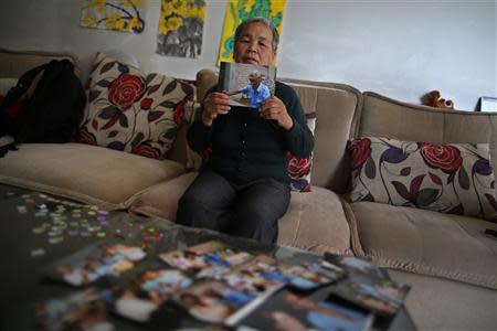 Liu Guolian poses for photograph as she holds a picture of her father Liu Qian, who was a forced labourer by Mitsui Mining to work in their mines in Fukuoka of Japan, during an interview with Reuters on the outskirts of Beijing, April 28, 2014. REUTERS/Petar Kujundzic