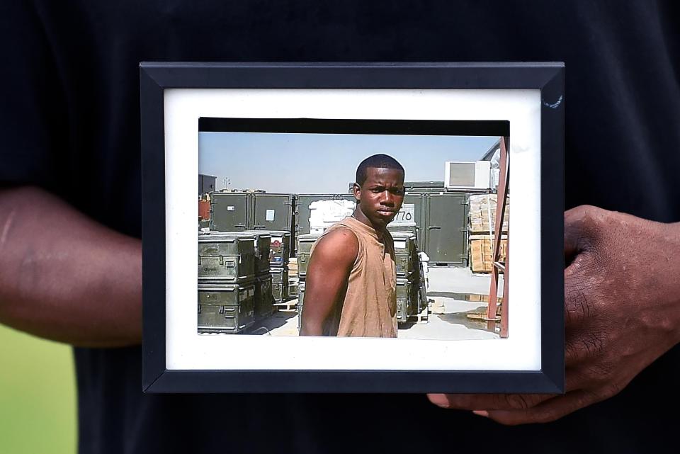 A family member holds up a photo of Adrian Jason Roberts at a vigil on Aug. 20, 2020.