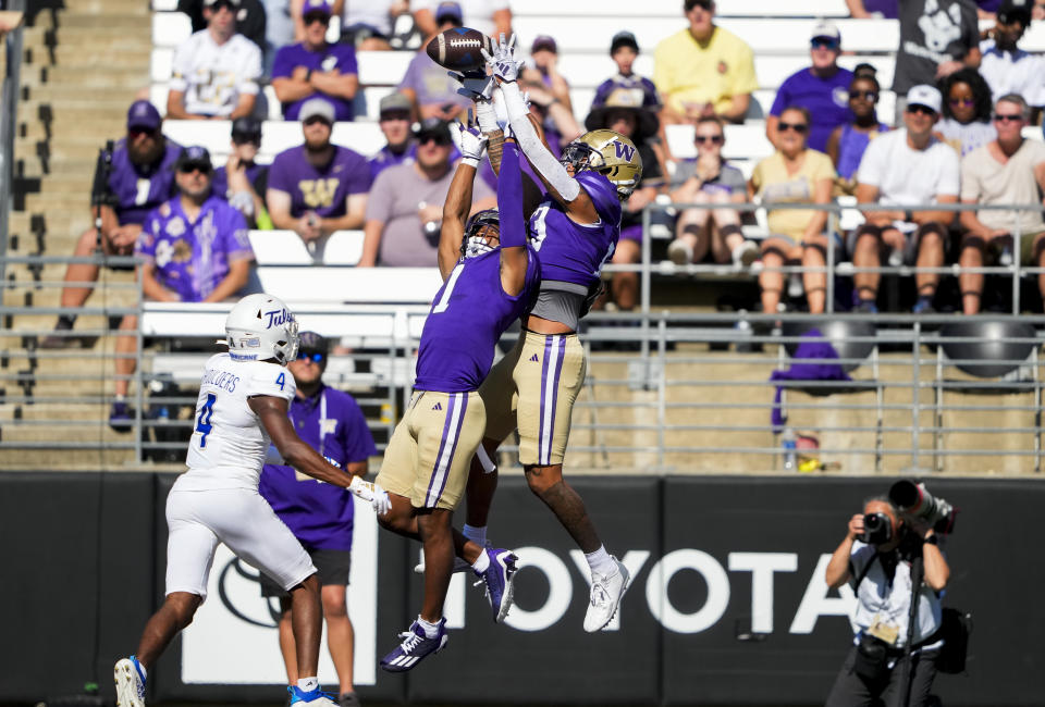 Washington cornerback Kamren Fabiculanan, top right, jumps above teammate Jabbar Muhammad (1) to make an interception against Tulsa wide receiver Marquis Shoulders (4) during the first half of an NCAA college football game Saturday, Sept. 9, 2023, in Seattle. (AP Photo/Lindsey Wasson)