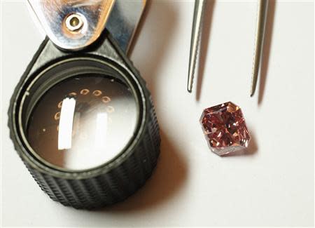 A Rio Tinto pink diamond is displayed along with tweezers and a magnifier in Hong Kong September 6, 2013. REUTERS/Bobby Yip