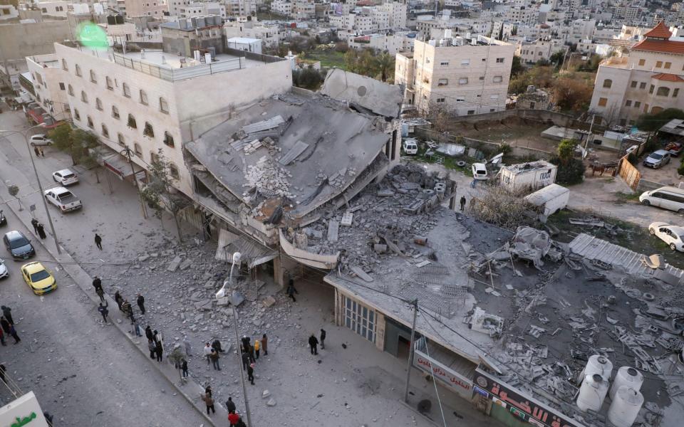 Palestinians gather near the rubble of a house demolished by Israeli forces earlier during a raid in Hebron city in the occupied West Bank