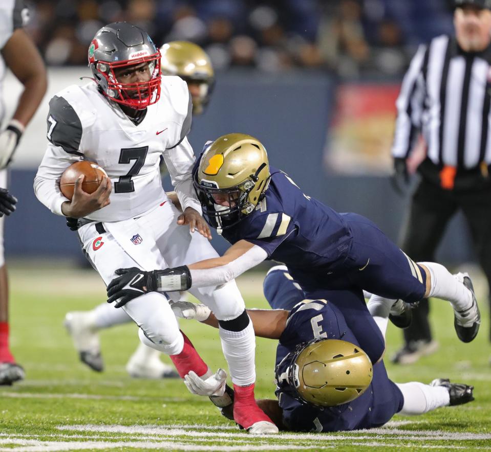 Hoban football's Rickey Williams, bottom, and Tanner Mintz tackle Toledo Central Catholic quarterback Ty'Wuan Clark in the OHSAA Division II state final Dec. 1, 2022, in Canton.