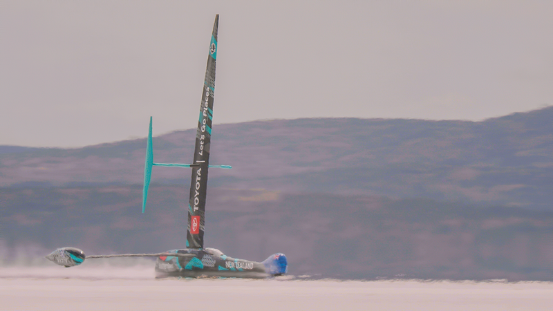 The black and teal-blue land yacht speeding across the lake bed.