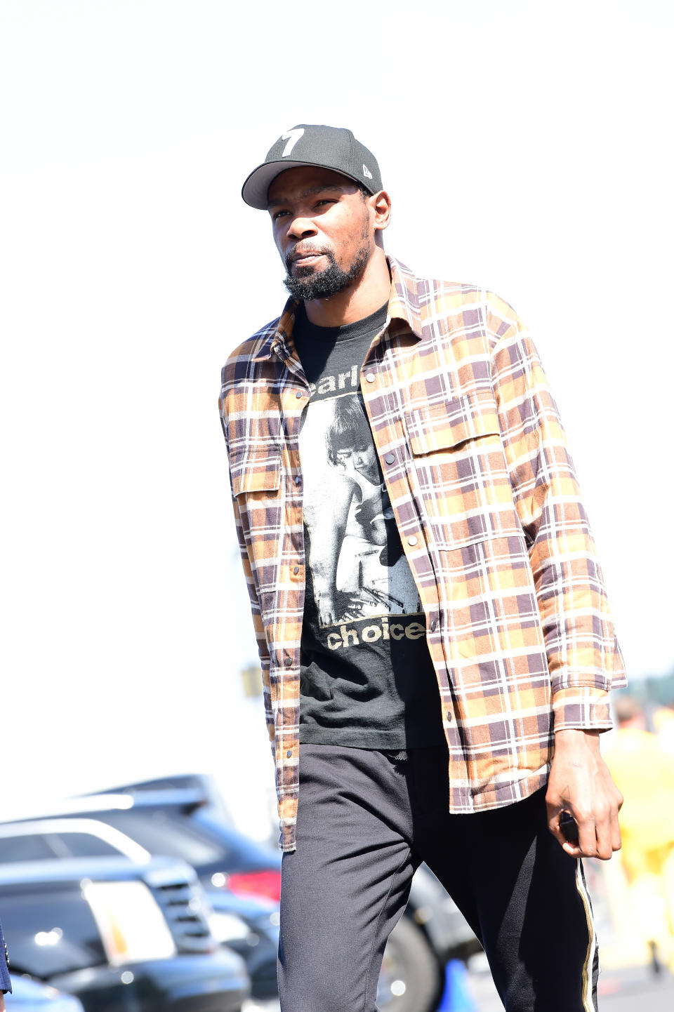 Kevin Durant wears a Pearl Jam "Choices" t-shirt underneath a brown flannel.