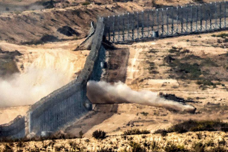 Un tanque de batalla del ejército israelí cruza una valla de alambre de púas en una posición a lo largo de la frontera con la Franja de Gaza y el sur de Israel el 8 de noviembre de 2023