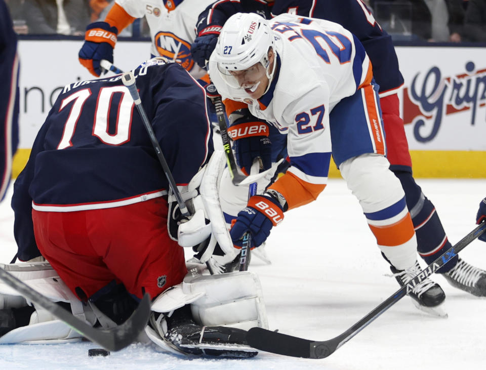 Columbus Blue Jackets goalie Joonas Korpisalo, left, stops a shot in front of New York Islanders forward Anders Lee during the first period of an NHL hockey game in Columbus, Ohio, Friday, Nov. 25, 2022. (AP Photo/Paul Vernon)