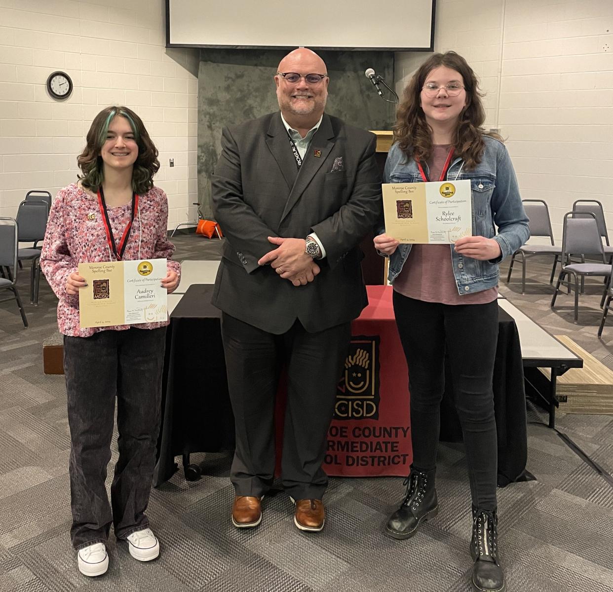 Monroe County Intermediate School District Superintendent Stephen McNew congratulates 2024 Monroe County Spelling Bee seventh and eighth grade winners Audrey Camilleri of Jefferson Middle School, left, and Rylee Schoolcraft of Ida Middle School.