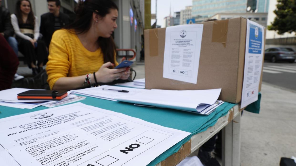 Eine Frau betreut einen Stand, an dem Anhänger der rechtspopulistischen Partei Lega über den Regierungsvertrag in Italien abstimmen. Foto: Antonio Calanni/AP