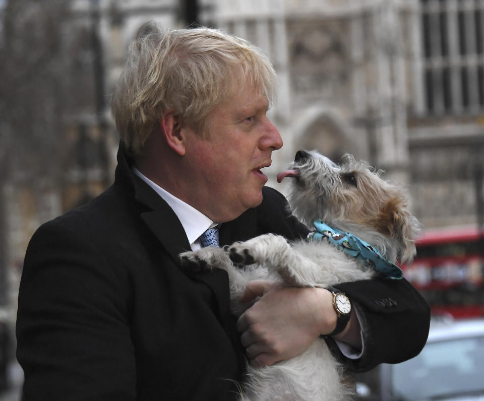 Britain's Prime Minister and Conservative Party leader Boris Johnson holds his dog Dilyn after voting in the general election at Methodist Central Hall, Westminster, London, Thursday, Dec. 12, 2019. The general election in Britain on Thursday will bring a new Parliament to power and may lead to a change at the top if Prime Minister Boris Johnson's Conservative Party doesn't fare well with voters. Johnson called the early election in hopes of gaining lawmakers to support his Brexit policy. (AP Photo/Alberto Pezzali)