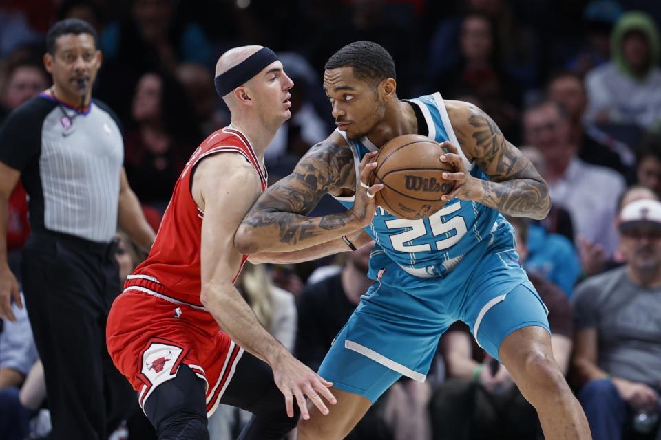 Charlotte Hornets forward P.J. Washington (25) looks to drive against Chicago Bulls guard Alex Caruso during the first half of an NBA basketball game in Charlotte, N.C., Friday, March 31, 2023. (AP Photo/Nell Redmond)