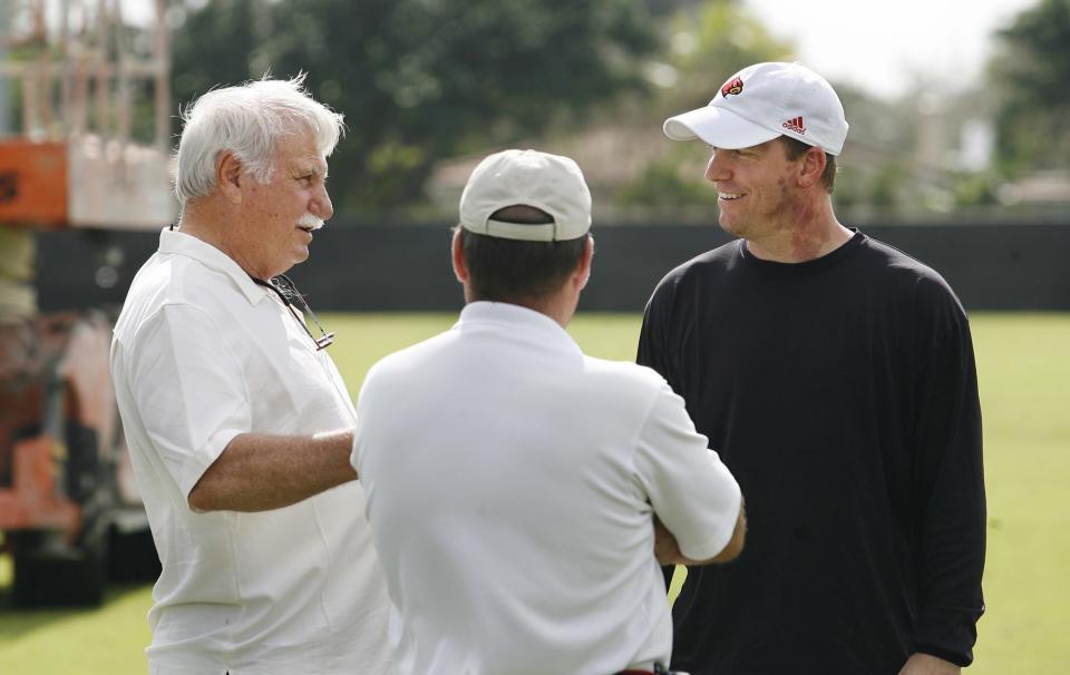 Former UofL head football coach Howard Schnellenberger, left, chatted with his former QB and current UofL QB's coach Jeff Brohm, right, after UofL practiced at the Barry University in Miami Shores, Florida.  Howard's former assistant coach at UofL Kurt VanValkenburgh, center, looked on.  The Cardinals are preparing for their upcoming Orange Bowl appearance on Jan. 2._To go with a Brian Bennett story.  