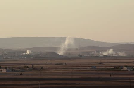 Smoke rises from the Syrian town of Kobani during what activists said were clashes between Islamic State fighters and Kurdish fighters, as seen from a hill in Tal-Hajeb village that overlooks the town, October 7, 2014. REUTERS/Stringer