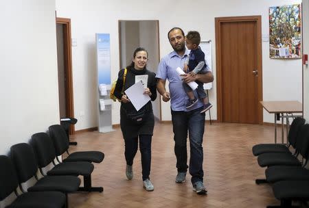 Syrian couple Hassan Zaheda, 31, and Nour Essa (L), 30, walk with their son Riad, 2, following an interview with Reuters at Sant'Egidio community in Rome, Italy, April 20, 2016. REUTERS/Max Rossi