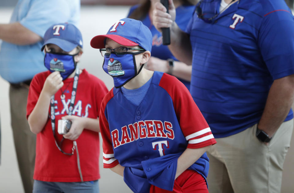 Gavin Bollmer, left, and his buddy, Austin LaFountain, wear masks as they tour Globe Life Field, home of the Texas Rangers baseball team, on the first day of public tours in Arlington, Texas, Monday, June 1, 2020. The robust TV experience available to sports fans has caused a decline in ticket sales for years, and now the coronavirus pandemic is forcing leagues to have games without them at all. But once they are allowed back in the stadium, ensuring fans are safe while also being entertained will be of paramount importance. (AP Photo/LM Otero, File)