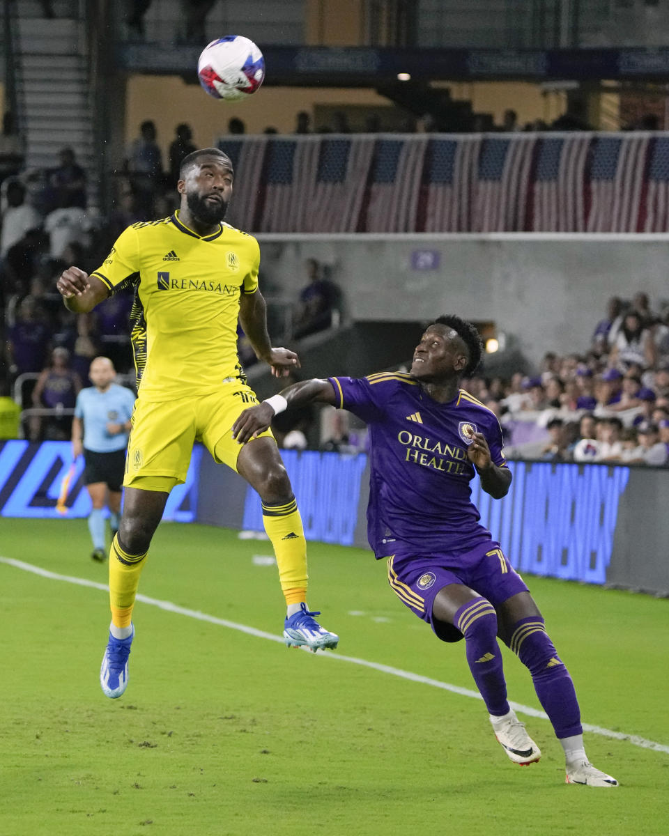 Nashville SC's Shaq Moore, left, goes up to get position on a head ball against Orlando City forward Ivan Angulo, right, during the second half of an MLS playoff soccer match, Monday, Oct. 30, 2023, in Orlando, Fla. (AP Photo/John Raoux)