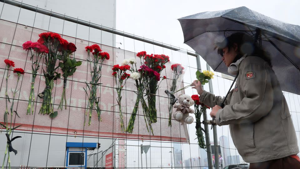 A person places flowers at a makeshift memorial in front of the Crocus City Hall. - Stringer/AFP/Getty Images