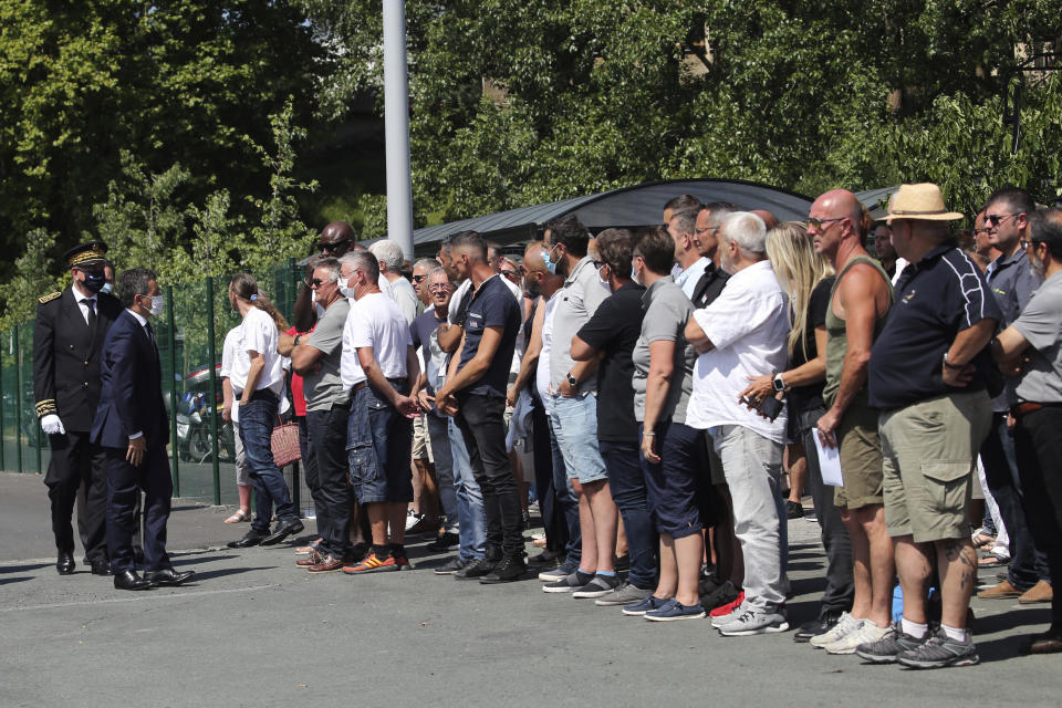 French Interior Minister Gerald Darmanin, left, arrives to talk with bus drivers in Bayonne, southwestern France, Saturday, July 11, 2020. The wife of a French bus driver savagely beaten after he asked four of his passengers to wear face masks aboard his vehicle called Saturday for "exemplary punishment" after he died of his injuries. (AP Photo/Bob Edme)