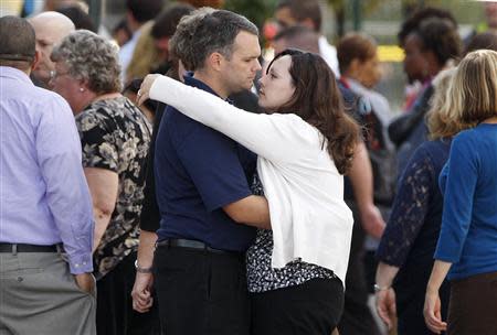 Navy Yard workers evacuated after the shooting are reunited with loved ones at a makeshift Red Cross shelter at the Nationals Park baseball stadium near the affected naval installation in Washington, September 16, 2013. REUTERS/Jonathan Ernst