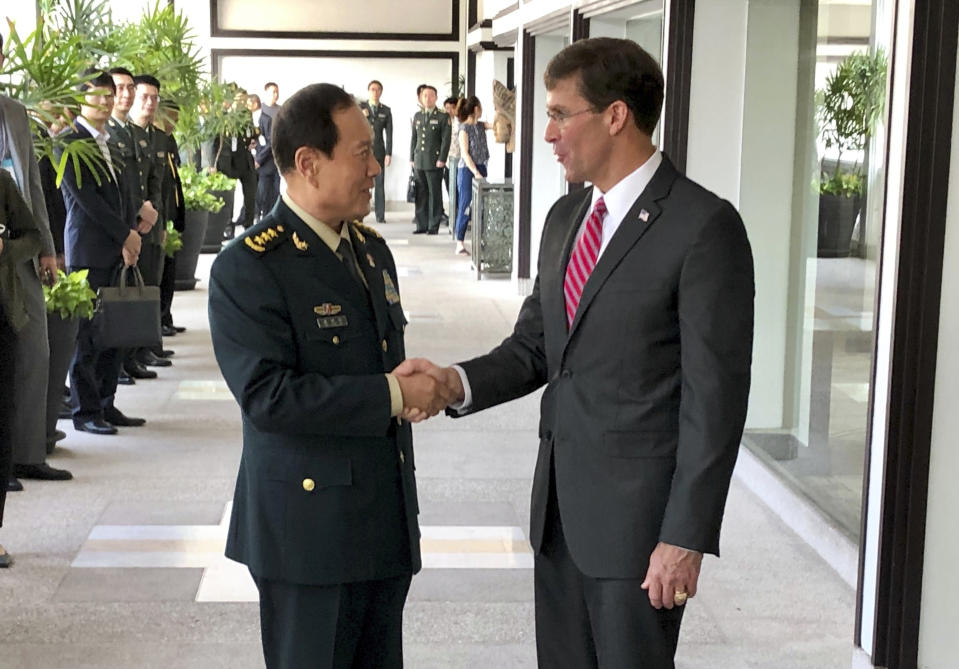 Chinese Defense Minister Wei Fenghe, left, greets U.S. Defense Secretary Mark Esper in Bangkok, Thailand, Monday, Nov. 18, 2019. The two held their first face-to-face talks Monday. (AP Photo/Robert Burns)